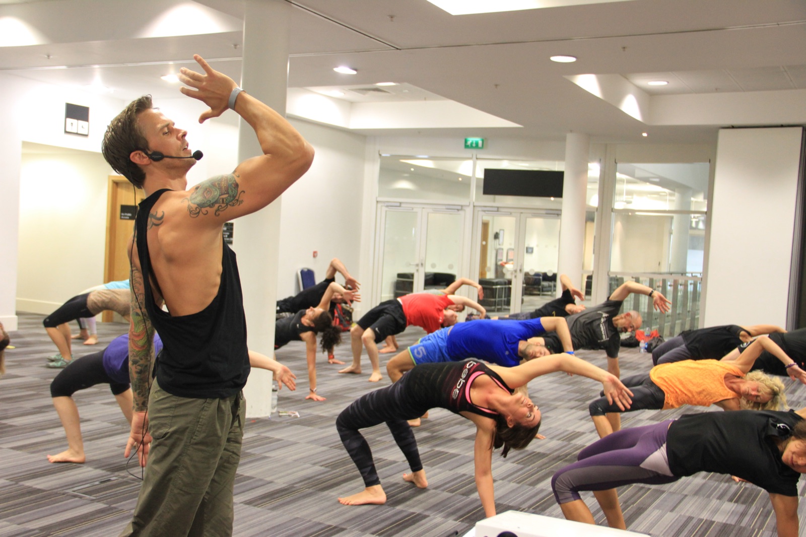 An instructor leading a group class through a reaching movement